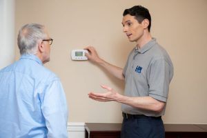 HVAC technician talking to a homeowner about his thermostat