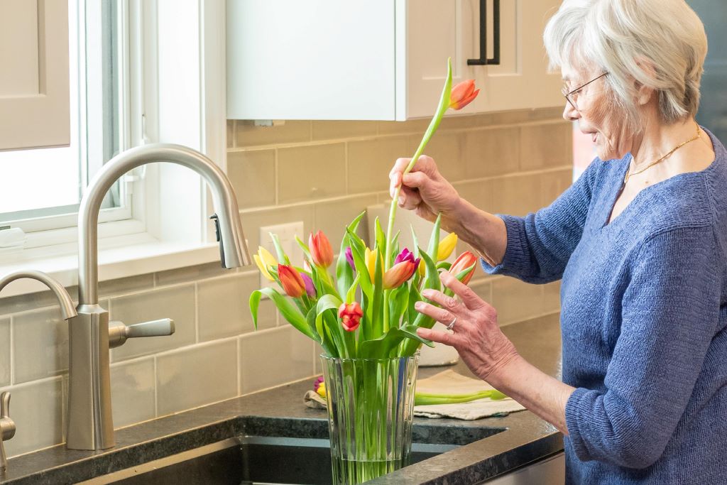 person putting tulips in vase in Baltimore home