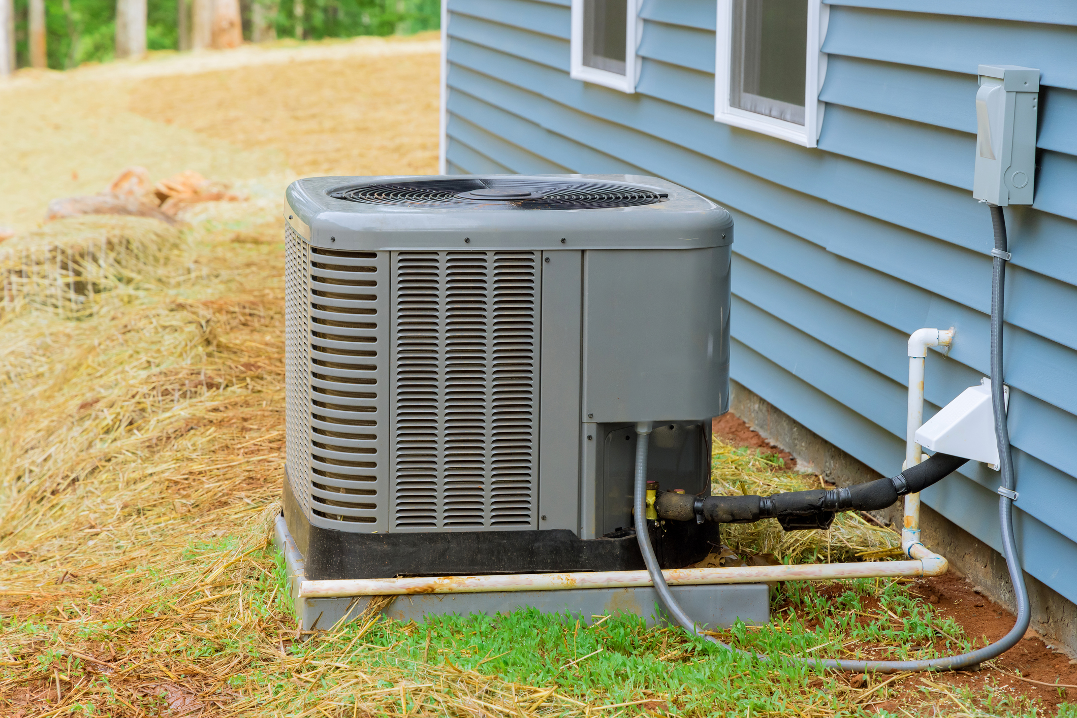 New air conditioner next to a blue house