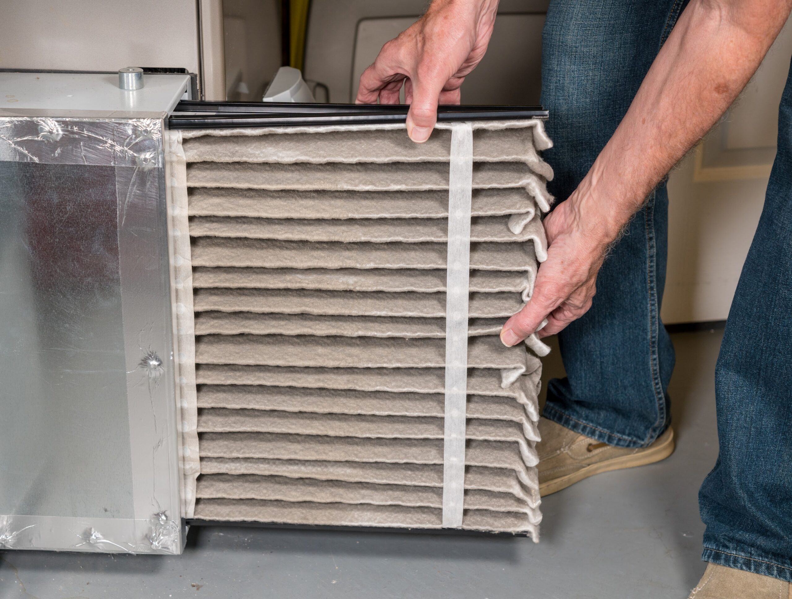 Closeup of man changing furnace filter