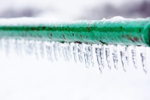 Frozen pipe covered in icicles