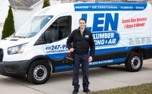 Technician standing in front of a Len The Plumber Heating & Air service truck