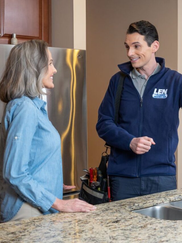 Plumber and homeowner standing by a kitchen sink