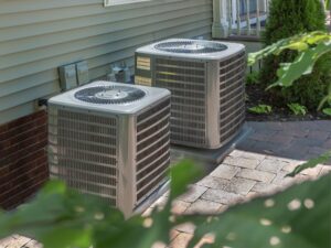 Two air conditioners outside of a home