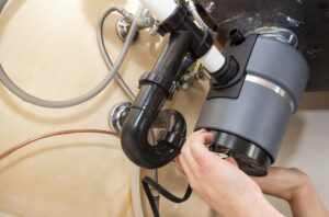 Man installing garbage disposal in home